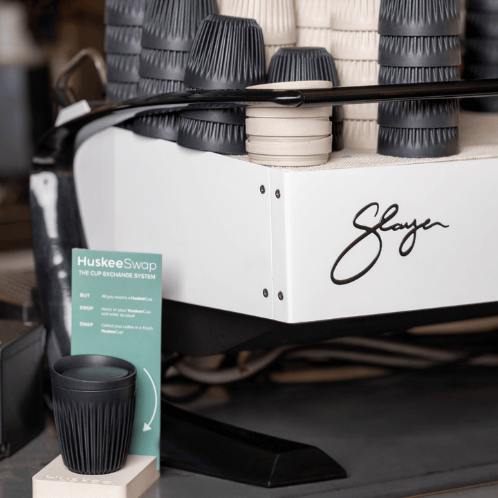 HuskeeSwap cups above espresso machine sign