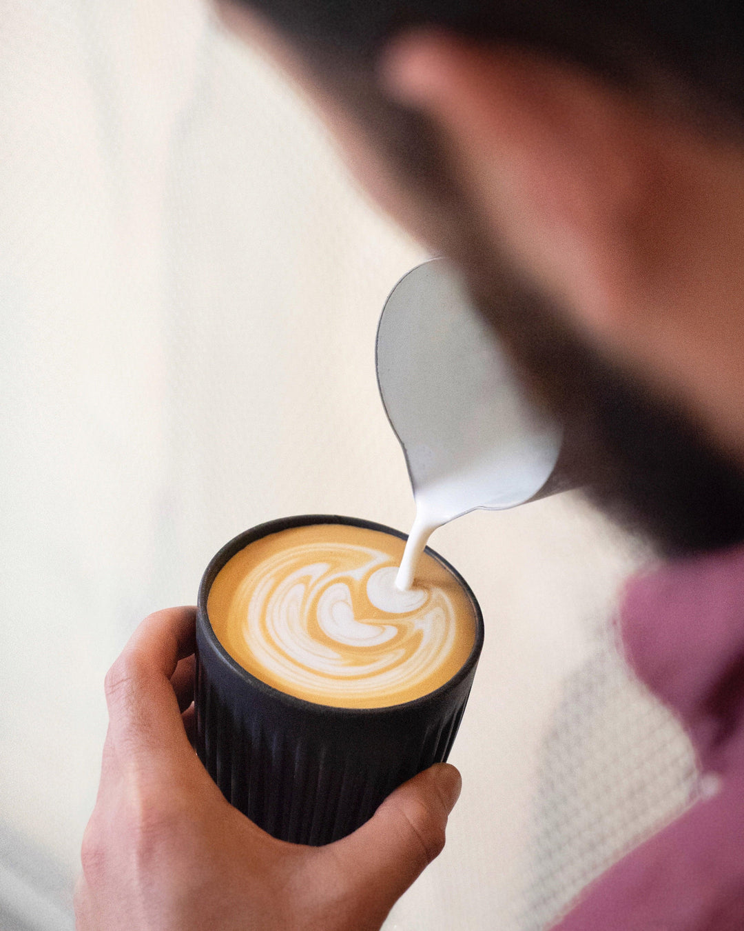 Latte art poured into charcoal HuskeeCup